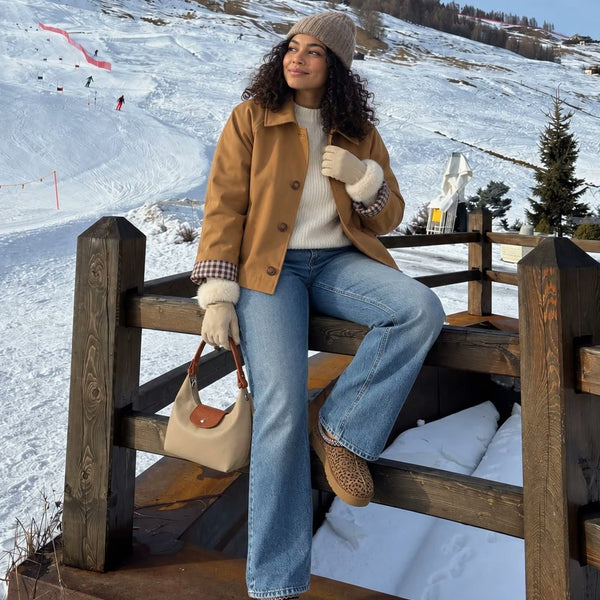 Woman on a ski slope fence in The London Trench in Camel and The Paris Glove in Light Beige