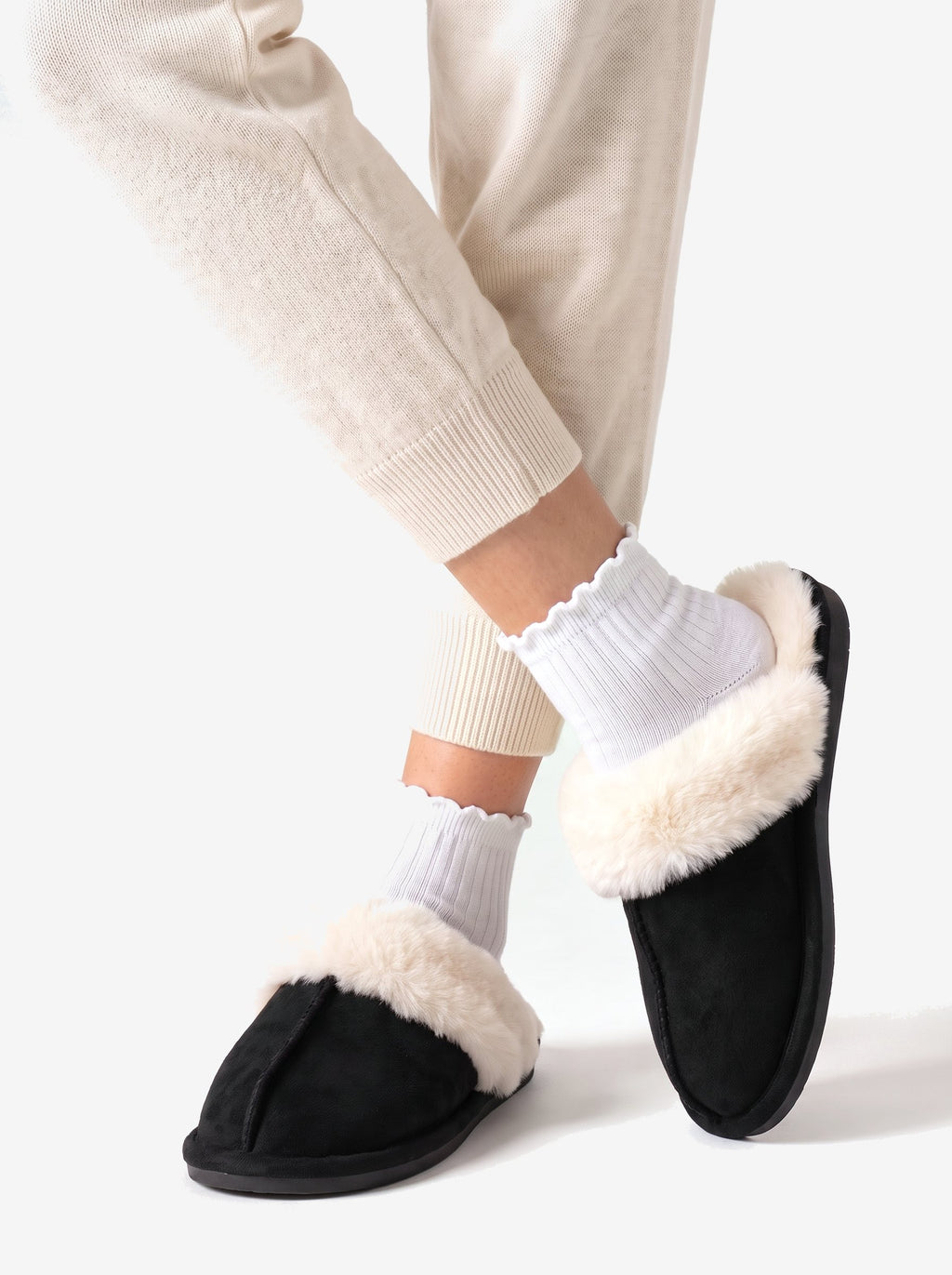 The Courchevel Slipper in Black, ankles crossed